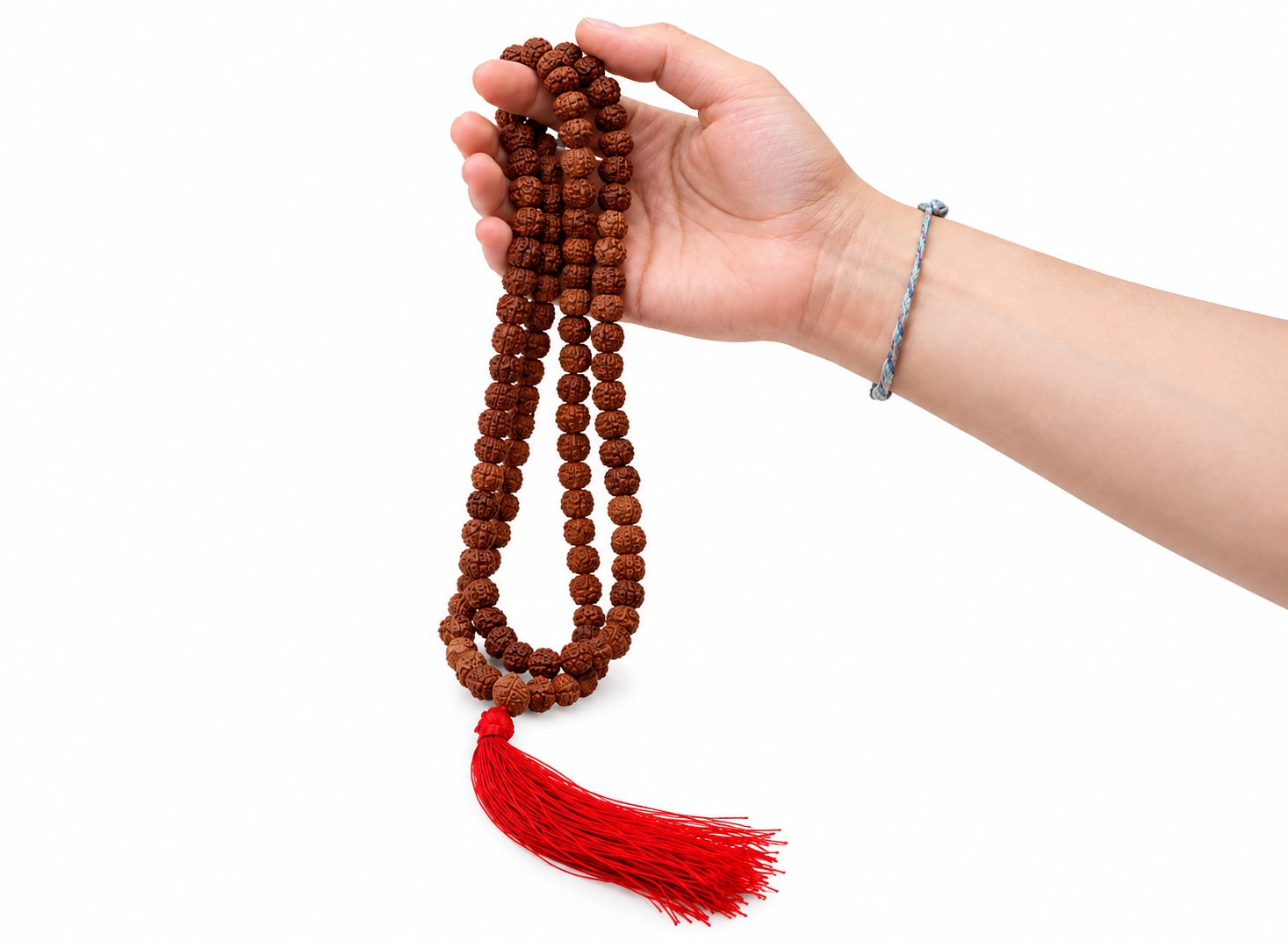 Różaniec „Rudraksha” – brązowa mala z czerwonym chwostem trzymana w dłoni